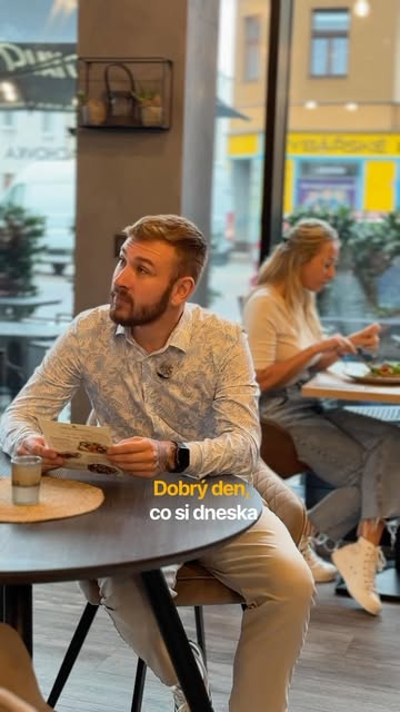 Host u stolu v Café Palachovka si vybírá z nabídky