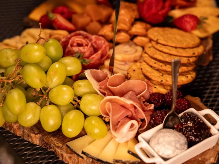 Tapas prkénko s prosciuttem, salámem, sýrem, krekry a hroznovým vínem